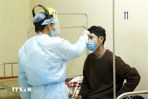 Nhân viên y tế kiểm tra thân nhiệt cho các ca bệnh đang được cách ly theo dõi nCoV tại Trung tâm Y tế Bình Xuyên. (Ảnh: Dương Ngọc/TTXVN)
