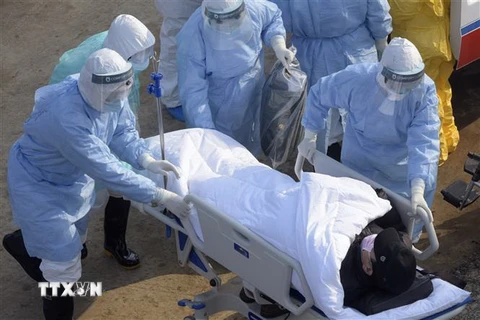 Nhân viên y tế hỗ trợ bệnh nhân nhiễm bệnh COVID-19 tới bệnh viện dã chiến ở Vũ Hán, tỉnh Hồ Bắc, Trung Quốc ngày 4/2/2020. (Ảnh: THX/TTXVN)