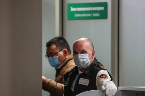 Nhân viên an ninh tại một sân bay ở Nga đeo khẩu trang để phòng dịch COVID-19. (Nguồn: Reuters)