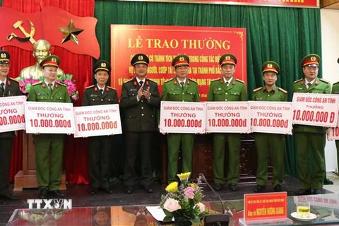 Đại tá Phạm Thế Tùng - Giám đốc Công an tỉnh Bắc Ninh trao thưởng cho các đơn vị tham gia phá án. (Ảnh: Đinh Văn Nhiều/TTXVN)