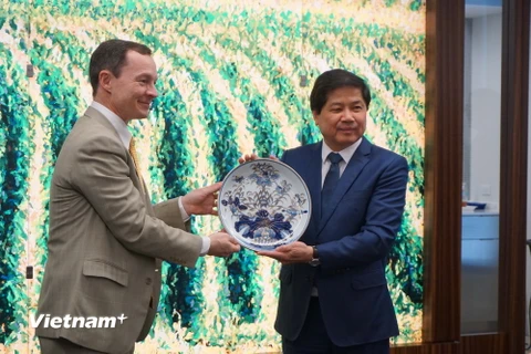 Thứ trưởng Lê Quốc Doanh tặng quà lưu niệm cho đại diện một hiệp hội ngành hàng của Mỹ. (Ảnh: Đặng Huyền/Vietnam+)