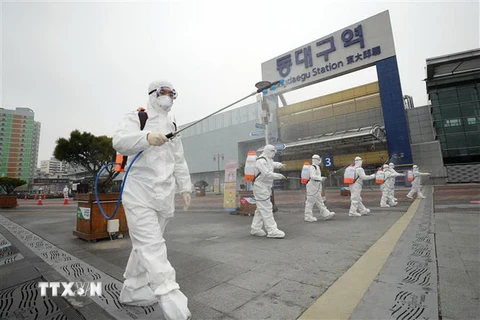 Nhân viên kiểm dịch phun thuốc khử trùng nhằm ngăn chặn sự lây lan của dịch COVID-19 tại khu vực nhà ga ở thành phố Daegu, Hàn Quốc ngày 29/2/2020. (Ảnh: Yonhap/TTXVN)