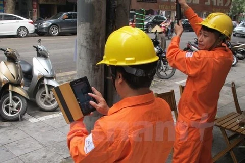 Nhân viên ngành điện đang chốt chỉ số công tơ của khách hàng. (Nguồn: Vietnam+)