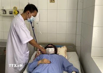  Bác sỹ thăm khám cho bệnh nhân Nguyễn Thị Thùy D. (Ảnh: TTXVN)