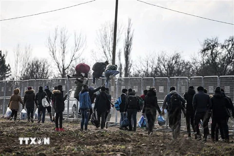 Người di cư cố vượt qua hàng rào ở biên giới giữa Thổ Nhĩ Kỳ và Hy Lạp trong hành trình tới châu Âu ngày 4/3/2020. (Ảnh: AFP/TTXVN)