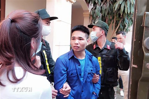 Đối tượng Trần Văn Bằng bị dẫn giải ra xe chở phạm nhân. (Ảnh: Quốc Đạt/TTXVN)