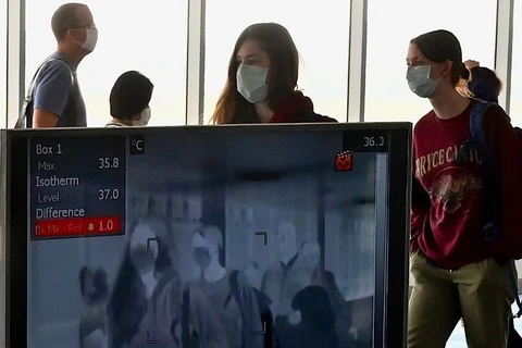 Hành khách được kiểm tra thân nhiệt tại sân bay quốc tế Wattay ở thủ đô Vientiane. (Nguồn: AFP)