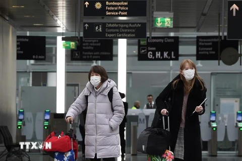 Hành khách đeo khẩu trang phòng dịch COVID-19. (Ảnh: AFP/TTXVN)