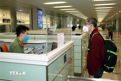 Lực lượng Công an cửa khẩu Cảng hàng không Quốc tế Nội Bài kiểm tra hộ chiếu của hành khách nhập cảnh. (Ảnh: Doãn Tấn/TTXVN)