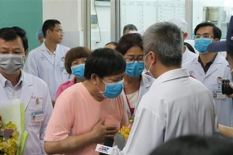 Bệnh nhân Li Ding (áo hồng), một trong hai bện nhân nhiễm SARS-CoV-2, cúi đầu cảm ơn các bác sỹ Việt Nam. (Ảnh: Đinh Hằng/TTXVN)