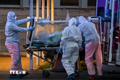 Nhân viên y tế chuyển bệnh nhân mắc COVID-19 tại một bệnh viện ở Rome, Italy ngày 16/3/2020. (Ảnh: AFP/TTXVN)