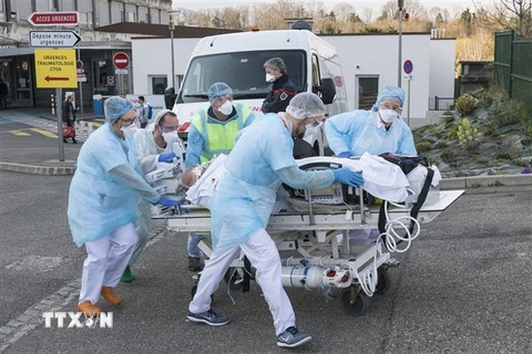 Nhân viên y tế chuyển bệnh nhân khỏi bệnh viện Emile Muller ở Mulhouse, miền Đông Pháp trong bối cảnh dịch COVID-19 bùng phát, ngày 17/3/2020. (Ảnh: AFP/TTXVN)