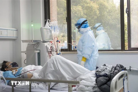 Nhân viên y tế điều trị cho bệnh nhân nhiễm COVID-19 tại bệnh viện Hán Khẩu ở Vũ Hán, Trung Quốc ngày 21/3/2020. (Ảnh: THX/TTXVN)