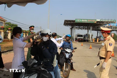 Lực lượng chức năng đo thân nhiệt các lái xe môtô đi vào địa bàn tỉnh Đắk Nông. (Ảnh: Ngọc Minh/TTXVN)