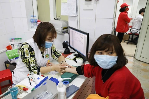 Lấy mẫu máu xét nghiệm cho tình nguyện viên đăng ký hiến máu tại địa chỉ 26 Lương Ngọc Quyến, quận Hoàn Kiếm, Hà Nội. (Ảnh: TTXVN)