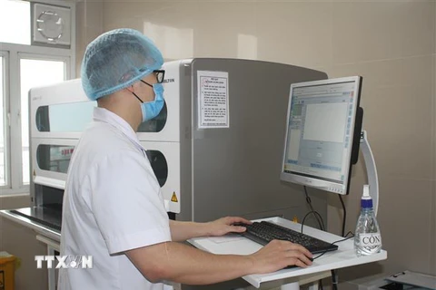 Cán bộ y tế Bệnh viện Đa khoa tỉnh Ninh Bình xét nghiệm mẫu trên máy xét nghiệm Real time PCR. (Ảnh: Thùy Dung/TTXVN)