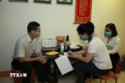 Bưu điện kết hợp với Bảo hiểm xã hội thành phố Hà Nội tổ chức chi trả lương hưu tại nhà. (Ảnh: TTXVN)
