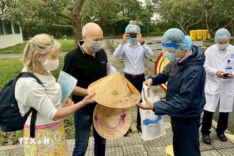 Lãnh đạo Sở Du lịch tỉnh Thừa Thiên-Huế tặng nón lá lưu niệm cho nữ bệnh nhân số 30. (Ảnh: Mai Trang/TTXVN)