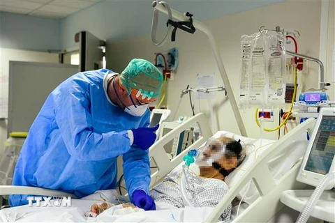 Nhân viên y tế động viên một bệnh nhân mắc COVID-19 tại một bệnh viện ở Bergamo, Italy ngày 3/4/2020. (Ảnh: AFP/TTXVN)