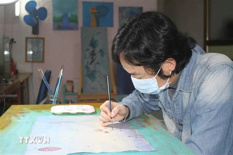 Họa sỹ Phan Tuấn Ngọc vẽ tranh với chủ đề 'Hãy ở nhà.' (Ảnh: Thùy Dung/TTXVN)