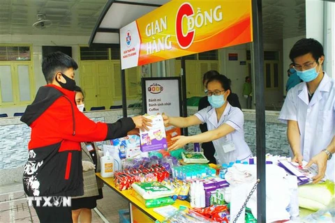 Bệnh nhân và người nhà bệnh nhân đến gian hàng 0 đồng tại Bệnh viện Sản nhi Nghệ An. (Ảnh: Tá Chuyên/TTXVN)