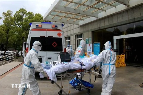 Nhân viên y tế chuyển bệnh nhân nhiễm COVID-19 tới bệnh viện ở Vũ Hán, tỉnh Hồ Bắc, Trung Quốc, ngày 11/4/2020. (Ảnh: THX/TTXVN)
