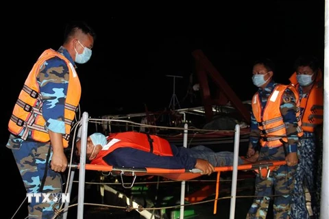 Lực lượng Cảnh sát biển 4 kịp thời đưa ngư dân Lê Văn Tuấn Em lên bờ an toàn chuyển đi cấp cứu. (Ảnh: TTXVN)