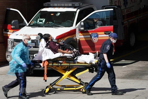 Nhân viên y tế chuyển bệnh nhân mắc COVID-19 từ xe cứu thương vào một bệnh viện ở New York, Mỹ ngày 6/4/2020. (Ảnh: AFP/TTXVN)