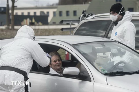 Nhân viên y tế kiểm tra thân nhiệt của người dân lưu thông qua khu vực biên giới giữa Cộng hòa Séc và Đức tại Rozvadov (Séc) nhằm ngăn dịch COVID-19 lây lan. (Ảnh: AFP/TTXVN)