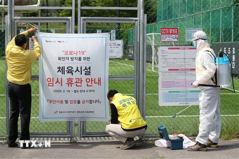 Nhân viên dỡ tấm biển đóng cửa tạm thời do dịch COVID-19 tại một sân bóng đá ở Seoul, Hàn Quốc, ngày 4/5/2020. (Ảnh: Yonhap/TTXVN)