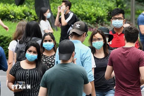 Người dân đeo khẩu trang phòng lây nhiễm COVID-19 tại Singapore ngày 5/4/2020. (Ảnh: AFP/TTXVN)