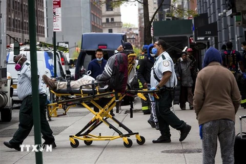 Lực lượng phản ứng nhanh chuyển một người nghi nhiễm COVID lên xe cứu thương ở khu Brooklyn, New York, Mỹ ngày 8/5/2020. (Ảnh: THX/TTXVN)