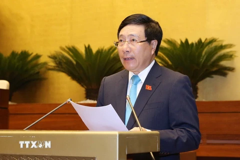 Phó Thủ tướng Chính phủ, Bộ trưởng Bộ Ngoại giao Phạm Bình Minh trình bày Tờ trình về dự án Luật Thỏa thuận quốc tế. (Ảnh: Phương Hoa/TTXVN)
