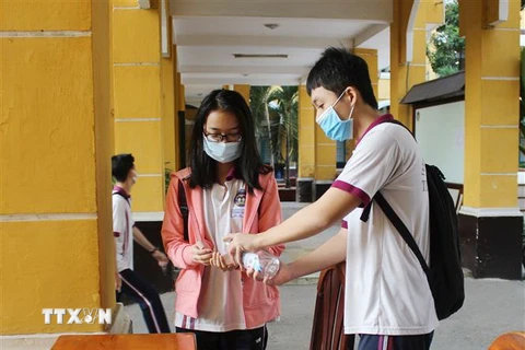 Học sinh rửa tay bằng dung dịch sát khuẩn trước khi vào lớp. (Ảnh: Xuân Anh/TTXVN)