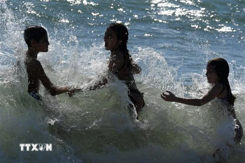 Trẻ em chơi đùa trên bãi biển tại Ladispoli, gần Rome, Italy ngày 24/5/2020. (Ảnh: THX/TTXVN)