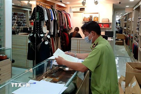 Lực lượng chức năng kiểm tra tại một cửa hàng phụ kiện thời trang ở quận 10. (Ảnh: Thành Chung/TTXVN)