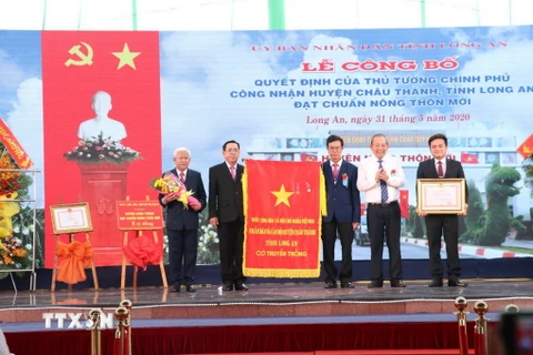 Phó Thủ tướng Trương Hòa Bình trao Huân chương Lao động hạng III cho Đảng bộ, chính quyền và nhân dân huyện Châu Thành vì thành tích trong phong trào xây dựng nông thôn mới. (Ảnh: Bùi Giang/TTXVN)