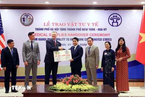 Chủ tịch Ủy ban Nhân dân thành phố Hà Nội Nguyễn Đức Chung trao tượng trưng số vật tư y tế cho Đại sứ Hoa Kỳ tại Việt Nam Daniel J. Kritenbrink. (Ảnh: Lâm Khánh/TTXVN)