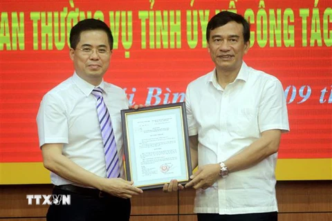 Ông Đặng Trọng Thăng, Chủ tịch UBND tỉnh Thái Bình (bên phải) trao quyết định của Thủ tướng Chính phủ cho ông Nguyễn Hoàng Giang. (Ảnh: Thế Duyệt/TTXVN)