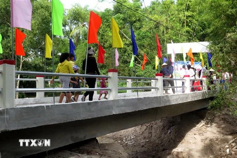 Người dân phấn khởi khi được đi trên cây cầu mới khang trang. (Ảnh: Phước Ngọc/TTXVN)