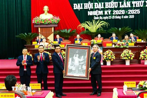 Ủy viên Bộ Chính trị, Bí thư Trung ương Đảng, Trưởng Ban Kinh tế Trung ương Nguyễn Văn Bình trao tặng bức ảnh Chủ tịch Hồ Chí Minh cho Đại hội. (Ảnh: Minh Tâm/TTXVN)