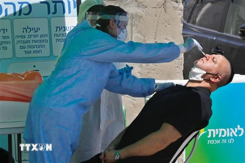 Nhân viên y tế lấy mẫu dịch xét nghiệm COVID-19 cho người dân tại thành phố Lod, Israel ngày 2/7/2020. (Ảnh: THX/TTXVN)