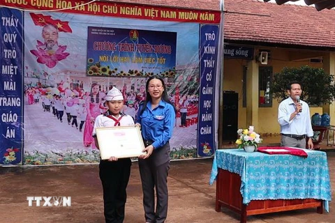 Lãnh đạo Tỉnh đoàn Bình Phước trao bằng khen cho em Thái Đình Nhân. (Ảnh: Đậu Tất Thành/TTXVN)