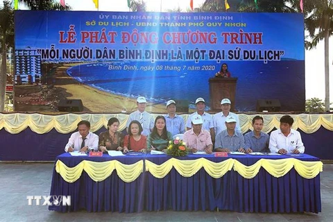 Đại diện các xã phường tại thành phố Quy Nhơn ký cam kết triển khai thực hiện chương trình 'Mỗi người dân Bình Định là một Đại sứ du lịch.' (Ảnh: Nguyên Linh/TTXVN)
