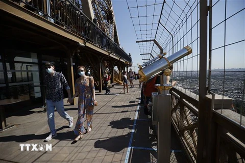 Du khách tham quan Tháp Eiffel tại thủ đô Paris, Pháp ngày 25/6/2020. (Ảnh: AFP/TTXVN)