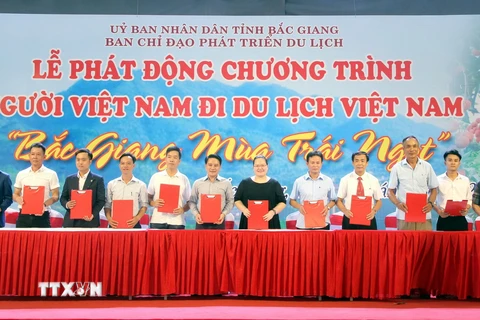 Các doanh nghiệp, cơ sở kinh doanh dịch vụ du lịch tại Bắc Giang ký kết chương trình kích cầu du lịch. (Ảnh: Đồng Thúy/TTXVN)
