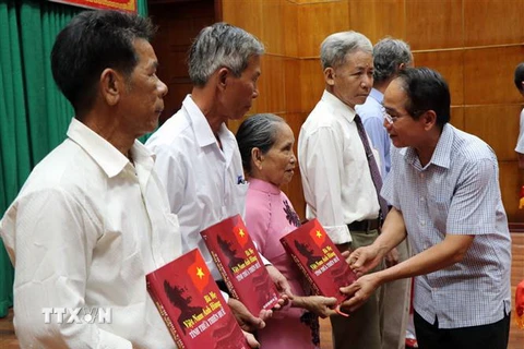Phó Bí thư Thường trực Tỉnh ủy Thừa Thiên-Huế Bùi Thanh Hà tặng sách cho thân nhân các Mẹ Việt Nam Anh hùng được ghi danh và ghi công trong cuốn sách. (Ảnh: Đỗ Trưởng/TTXVN)