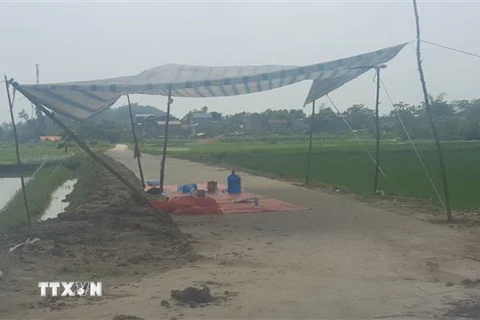 Người dân dựng lều bạt chốt chặn không cho xe chở rác vào bãi rác Nam Sơn. (Ảnh: Mạnh Khánh/TTXVN)