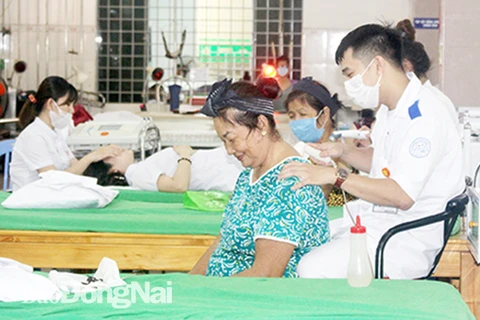 Các nhân viên y tế của Phòng Chẩn trị y học cổ truyền Thiên An thuộc Dòng trợ thế Thánh Gioan Thiên Chúa đang điều trị cho bệnh nhân. (Nguồn: Báo Đồng Nai)