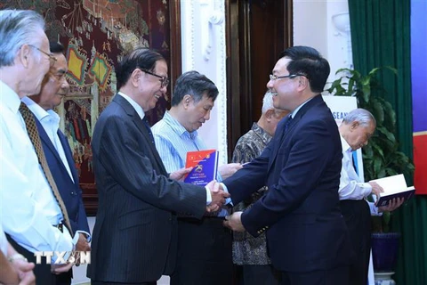 Phó Thủ tướng, Bộ trưởng Bộ Ngoại giao Phạm Bình Minh trao sách tặng các nguyên lãnh đạo Chính phủ và Bộ Ngoại giao. (Ảnh: Lâm Khánh/TTXVN)